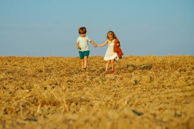 Doğadaki sevimli arkadaşlar için güzel eğlenceli bir gün. Çocukların yaz neşesi vardır. Çocuklar dışarıda oynar. Dışarıda eğlenirken. Pozitif küçük kız ve oğlan. Dışarıdaki küçük çocuk.