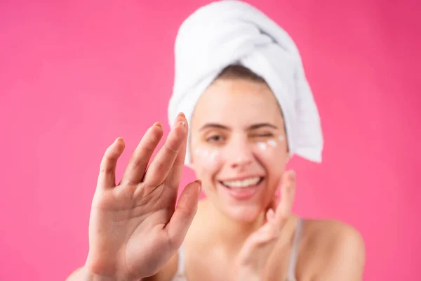 Kobieta w masce. Uroczy, ładny model po kąpieli owinięty ręcznikiem przy użyciu maski na twarz, zmysłowej twarzy. Piękna kobieta stosująca krem nawilżający na skórę przy użyciu kremu dotykającego twarzy. — Zdjęcie stockowe