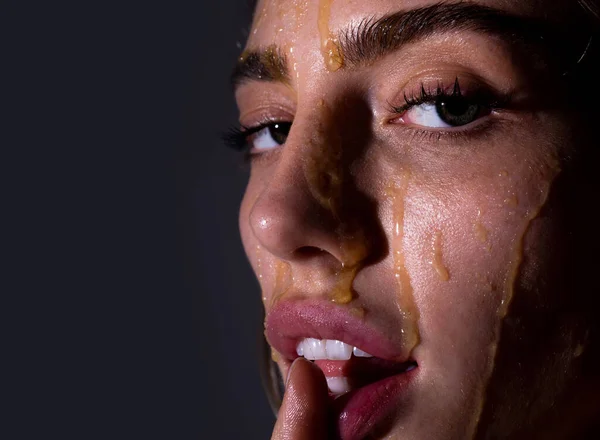 Beautiful young woman with honey on her face. Close up portrait of girl with a honey facialmask closeup. Beautiful woman with honey on her face. Healthy perfect skin. Honey treatment. — Photo