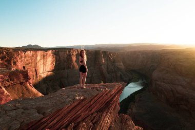 Büyük Kanyon 'da kaygısız bir kadın. Panoramik At Nalı Kıvrımı. Arizona 'da at nalı kıvrımının tadını çıkaran bir kadın..