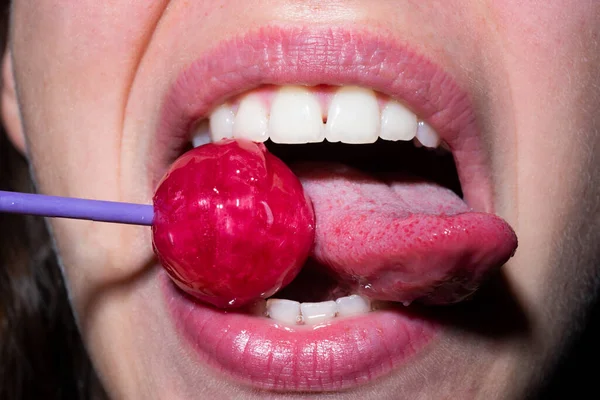 Zungenlippen lecken. sexuelle Lippen mit Bonbons, sexy süße Träume. weiblich mund leckt chupa chups, lutscher lutscher. — Stockfoto