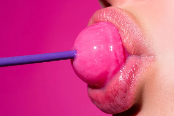 Sexy blow jobs symbol. Girl with sexy mouth eating chupa chups close up. Woman lips sucking lollypop. Woman holding lollipop in mouth, close up. Red lips, sensual and sex shop concept. — Stockfoto