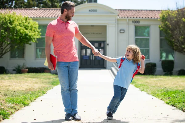 Father and son run with father after come back from school. Family education and school outdoor concept. — Stock Photo, Image