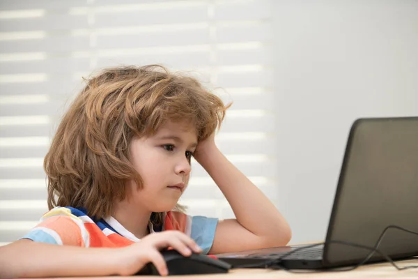Retrato de menino da escola olhando para o laptop durante a aula. Educação e aprendizagem para a criança. — Fotografia de Stock