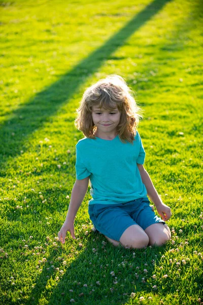 Красивый мальчик в парке выглядит счастливым. летний ребенок. — стоковое фото