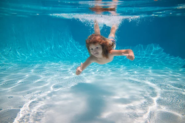 Miúdo a nadar debaixo de água e a sorrir. Criança feliz nada na piscina subaquática, criança ativa nadando debaixo d 'água, brincando e se divertindo, Crianças esporte aquático. Férias de verão com crianças. — Fotografia de Stock