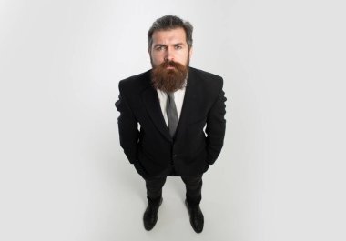 Komik adam, takım elbiseli iş adamı. Resmi takım elbiseli, elleri cebinde beyaz arka plan, geniş açı ve üst görüş açısından izole edilmiş bir adam..