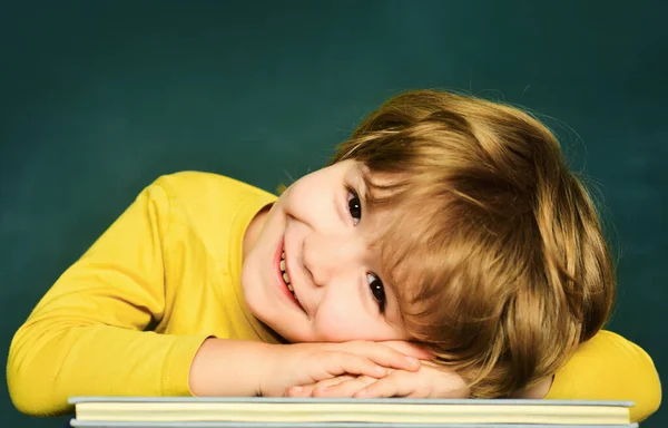 Talented child. Cute boy with happy face expression near desk with school supplies. School lessons. Little children at school lesson. — Stock Photo, Image