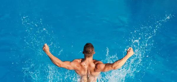 Athletischer Muskeltrainer im Schwimmbadkonzept. Schöner Kerl ruht sich aus, während er im Freien schwimmt. — Stockfoto