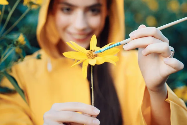 Дівчина малює квітку. Весняна чуттєва жінка з квіткою. Концепція дівчини-природи. Весняний живопис. Жовтий весняний настрій. Квітка на руках . — стокове фото