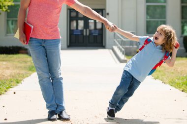 Baba ve heyecanlı oğul okul parkında yürüyor..