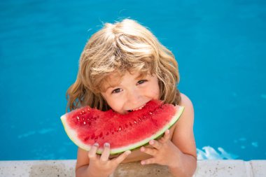 Havuzda karpuz olan bir çocuk. Çocuk yüzme havuzunda eğleniyor. Çocuklar yaz tatili ve sağlıklı beslenme konsepti.