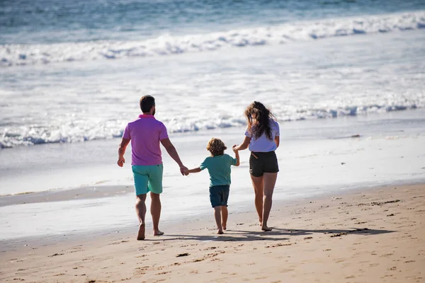 Famiglia felice che corre sulla spiaggia al tramonto. Concetto di famiglia itinerante. Famiglia Lifestyle. Concetto di vacanza sana e attività familiare. — Foto Stock