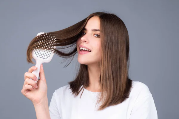 Mujer atractiva peinando el cabello. Hermosa chica peina el pelo. Concepto de cuidado del cabello. —  Fotos de Stock