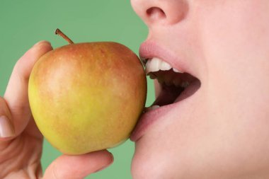 Diş bakımı. Sağlıklı beyaz dişler, elmayla yakın plan..