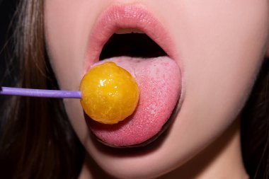 Close up lips with lollipop isolated, sexy blowjob, sensual mouth with lipstick eats sweets. Sexy design for women and girls. Beauty lips.
