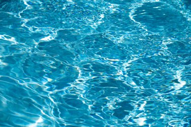 Yüzme havuzunda güneş yansımalı dalgalı su. Dalgalı su arkaplanı.