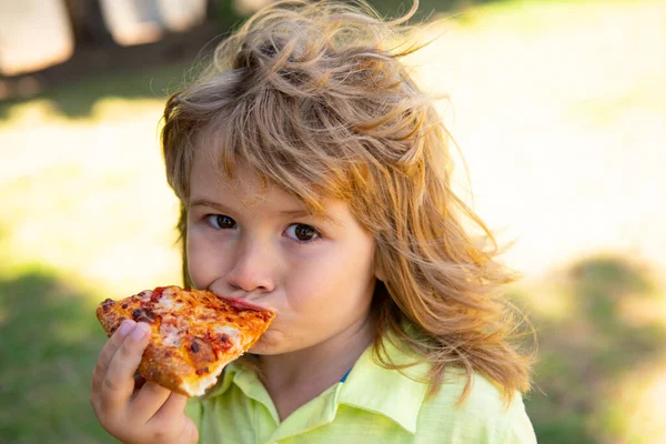 A un chico le gusta comer pizza. Comer pizza al aire libre. — Foto de Stock