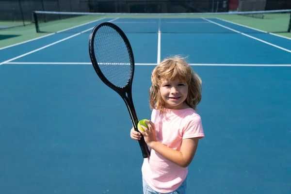 Niño niño jugador de tenis principiante en la cancha de tenis al aire libre. —  Fotos de Stock