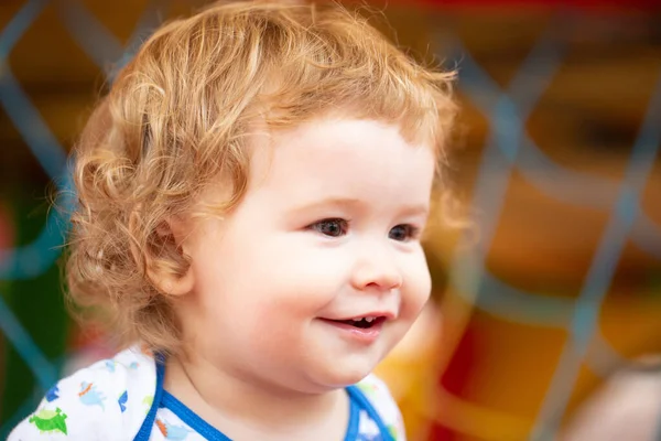 Πορτρέτο ενός χαρούμενου παιδιού που γελάει την ηλιόλουστη μέρα. Κλείστε τα θετικά παιδιά στην παιδική χαρά. Χαμογελαστό βρέφος, χαριτωμένο χαμόγελο. — Φωτογραφία Αρχείου