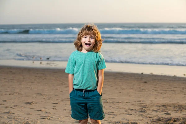 Παιδί με t-shirt που περπατάει στην καλοκαιρινή παραλία. Εκπλήσσομαι με τα συναισθήματα των παιδιών.. — Φωτογραφία Αρχείου