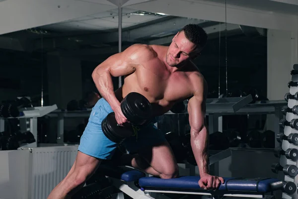 Hemdloser Sportler im Fitnessstudio. Bodybuilder trainieren Bizeps-Tricks mit Kurzhantelübungen. Sportlicher Lebensstil. — Stockfoto