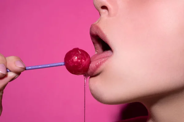 En sexig avsugningssymbol. Slicka godis. En klubba. Kvinnliga läppar suger godis. Oralsex avsugning koncept. Glamor sexig modell med röda läppar äter svettningar lolly pop. — Stockfoto