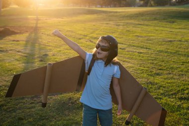 Çocuk oyuncak jetpack ile oynuyor. Çocuk pilot astronot ya da uzay adamı uçmayı hayal eder. Karton kanatlarla uçan havacı çocuk. Hayal, özgürlük ve seyahat konsepti.