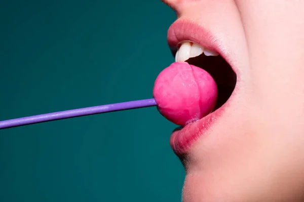 Mädchen mit sexy Mund essen Chupa Chups aus nächster Nähe. Frauenlippen lutschen Lollypop. Frau mit Lutscher im Mund, aus nächster Nähe. Rote Lippen, sinnliches und sexy Konzept. — Stockfoto