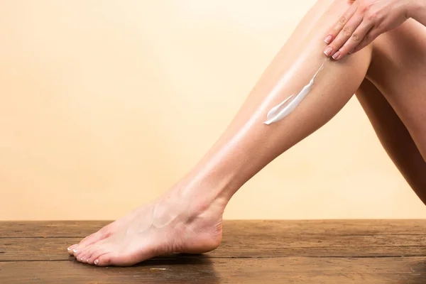 Cosmetische crème op vrouwenbeen met een schone zachte huid. Vochtinbrengende crème op de benen aanbrengen. Cellulitis of cellulitis behandeling. Lichaamsverzorging en spa salon concept. — Stockfoto