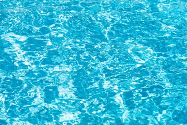 Su arka planı, dalgalanma dalgaları. Mavi yüzme havuzu deseni. Deniz yüzeyi. Yüzme havuzunda su ve güneş yansıması. Kopyalama alanı olan pankart.
