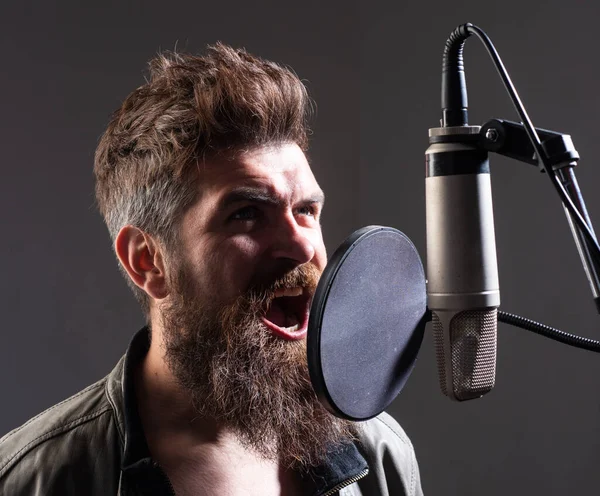 Nahaufnahme Porträt eines Mannes mit Mikrofon, der ein Lied singt. Musiker im Musiksaal. Lustiger Typ singt. — Stockfoto