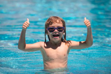 Havuzdaki aktiviteler, yüzen ve suda oynayan çocuklar, mutluluk çocukları ve yaz zamanı. Çocuk havuzda yüzüyor..