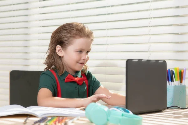 Terug naar school. Grappige schooljongen van de basisschool met boek en laptop. Onderwijs. Kind met schoolspullen. — Stockfoto