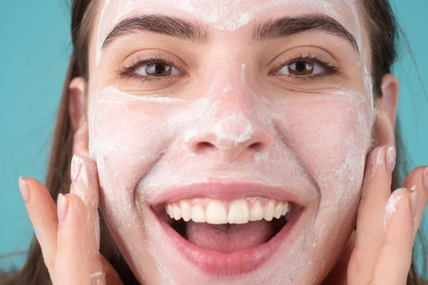 Maschera facciale da vicino, faccia di argilla. Bella donna sorridente con procedura cosmetica viso, concetto di pelle spa. Cura della pelle trattamento di bellezza. Cosmetologia e spa. — Foto Stock