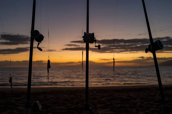 Canne à pêche et bobine sur la mer et le coucher du soleil ciel. — Photo
