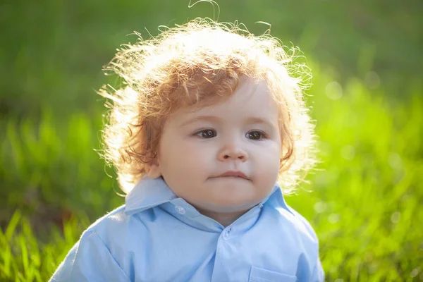 Feche o retrato de um bebê loiro no dia ensolarado. Engraçado crianças rosto no verão parque da natureza. — Fotografia de Stock