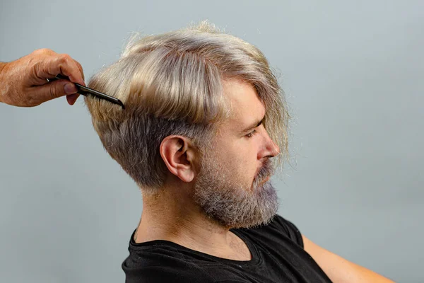 Professionelle Friseure machen Haarschnitt. Friseurkonzept. Männliche Kunden bekommen vom Friseur einen Haarschnitt. Porträt aus nächster Nähe. — Stockfoto