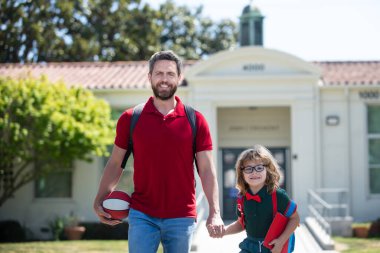 Baba oğlunu destekliyor ve motive ediyor. Çocuk eğitimi. Çocuk ilkokula gidiyor..