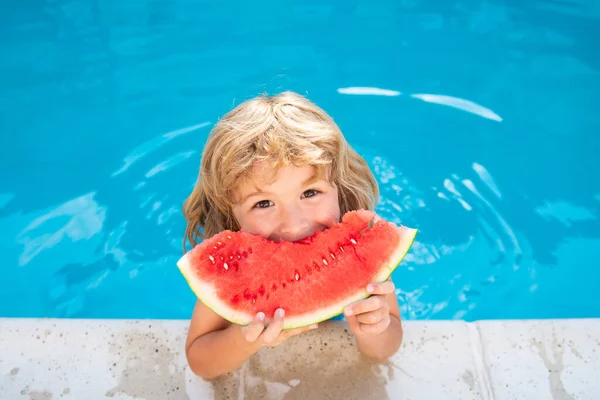 Niño con sandía en piscina. Los niños comen frutas de verano al aire libre. Niños sanos. — Foto de Stock