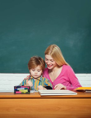 Anaokulu öğretmeni sınıfta küçük bir öğrenciye ders veriyor..