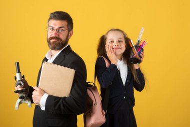 Okul üniformalı kız öğrenci ve öğretmen stüdyoda eğleniyor. Şaşırmış mutlu öğrenci ve öğretmen portresi..