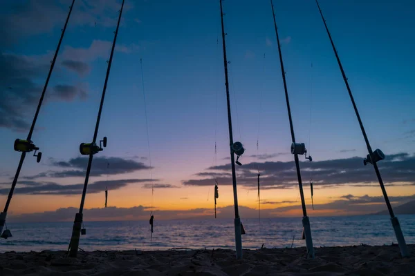 La canne à pêche tourne. cannes à pêche en raison de la journée de pêche au coucher du soleil sur la mer. Des anneaux de tige. Matériel de pêche. Enrouleur de pêche. — Photo