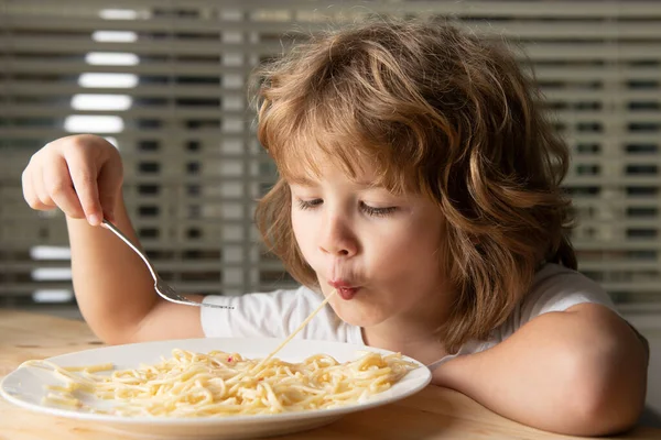 Close up head shot of child eating pasta, spaghetti. Kids face, little boy portrait. — Stock Photo, Image