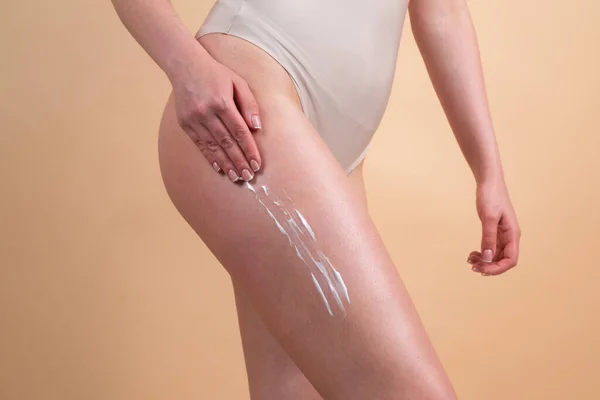 Körperpflege. Frau cremt Beine ein. Frauen, die Anti-Cellulite-Creme auftragen. Cellulite- oder Anti-Cellulitebehandlung. Körperpflege und Wellness-Salon-Konzept. — Stockfoto