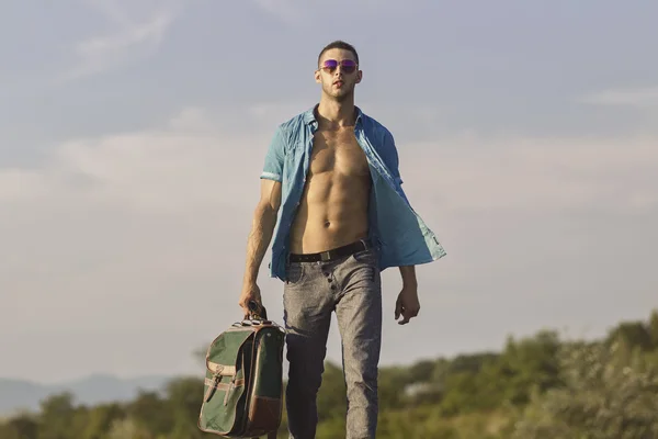 Sexy guy in motion with travel bag — Stock Photo, Image