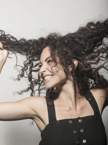 Beautiful cheerful woman holding a curly hair Royalty Free Stock Photos