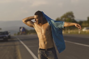 seksi bir adam yolda mavi gömlek koymak