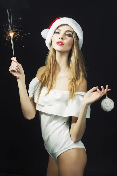 Beautiful woman in Santa Claus hat with New year party sparkler on black background — Stock Photo, Image