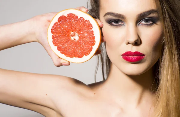 Preatty flicka anläggning grapefrukt — Stockfoto